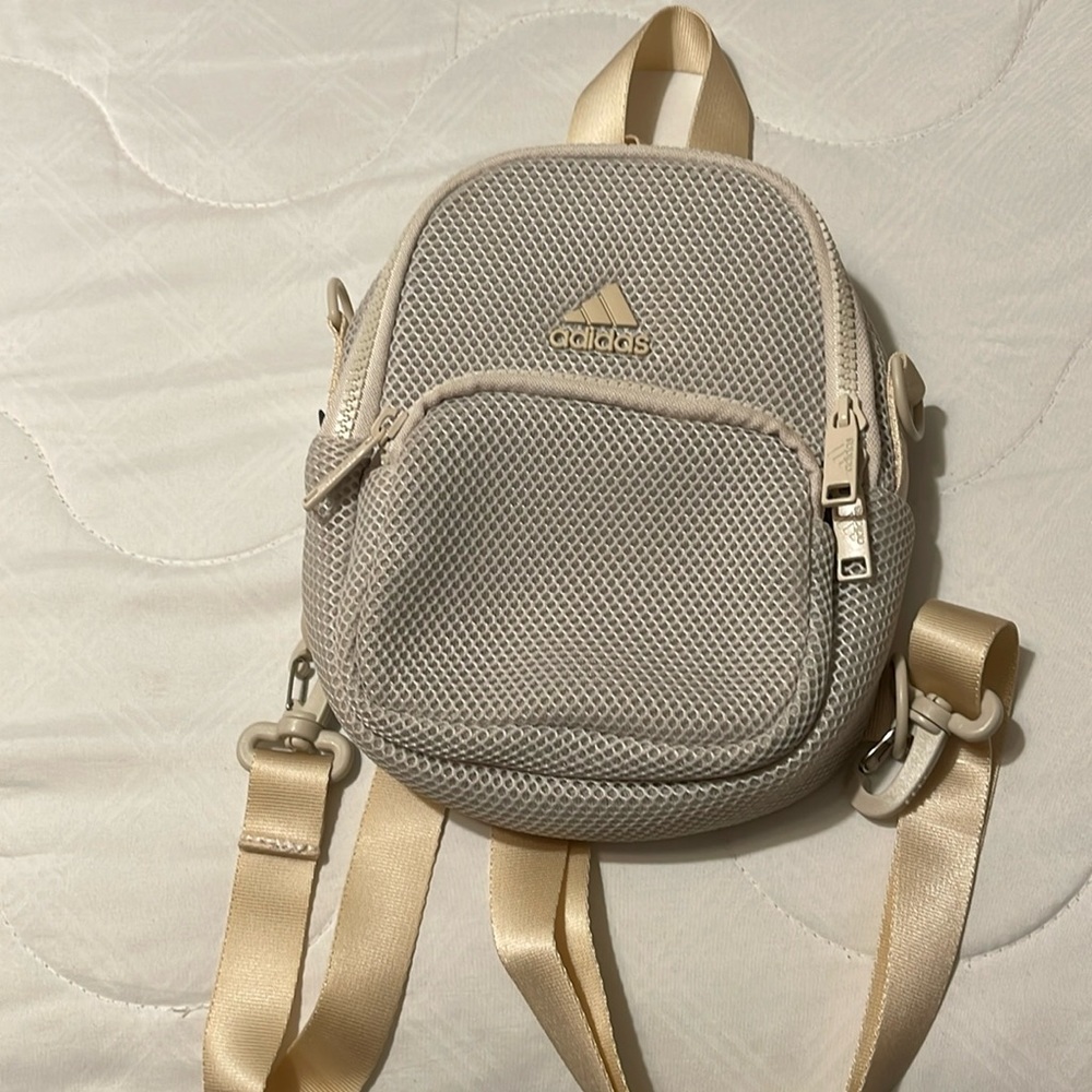 It’s a beige Adidas air mesh mini backpack used once.